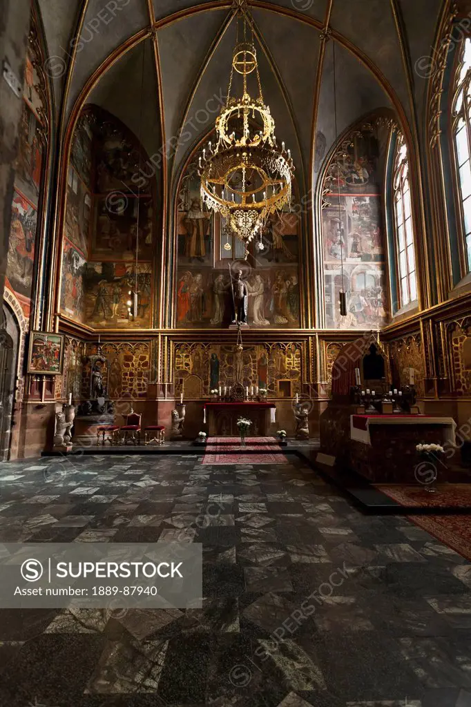 Czech Republic, Large Arched Windows And Chandelier; Prague, Interior Of Church With Colorful Depictions Painted On Walls