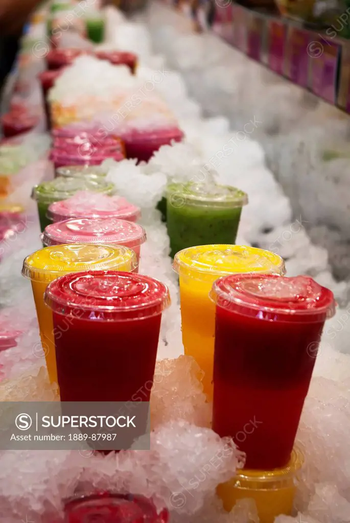 Spain, Catalonia, Cups Of Fresh Fruit Juices Stacked In Crushed Ice For Sale In La Boqueira; Barcelona