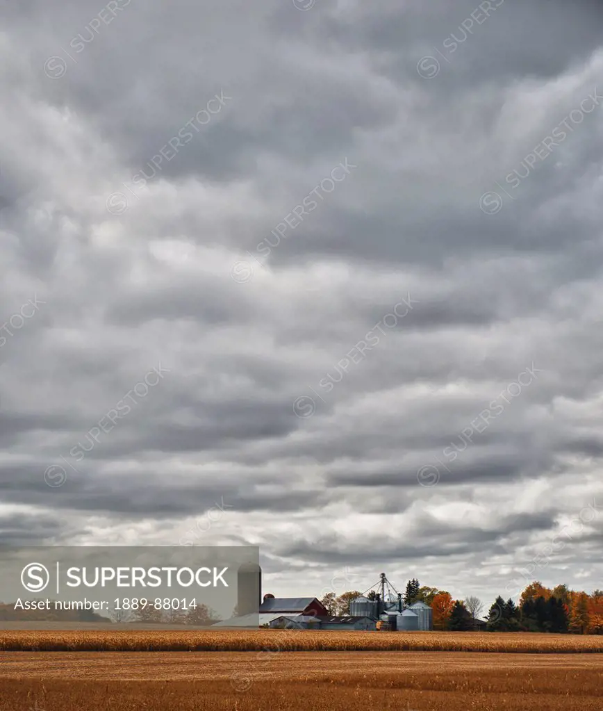 Canada, Near London; Ontario, Farmland And Farm Structures Under Cloudy Sky