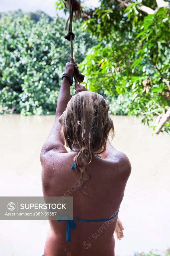 Woman Swinging Over Hule Ia River (Seen In Indiana Jones Film) On Kipu Ranch; Kauai Hawaii Usa