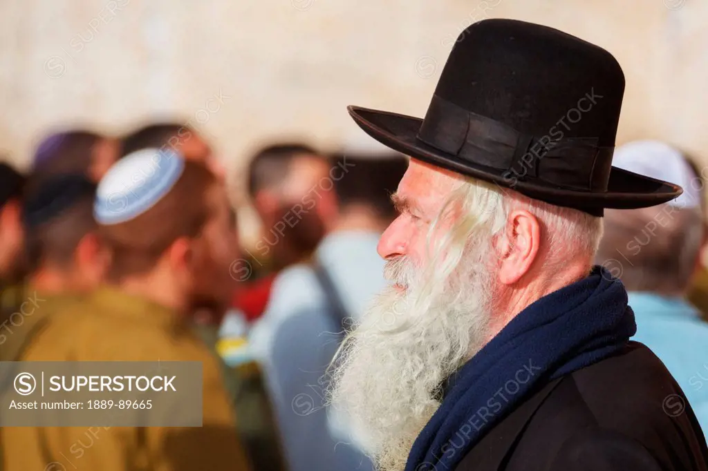 Side view of man with Wailing Wall in background; Jerusalem, Israel