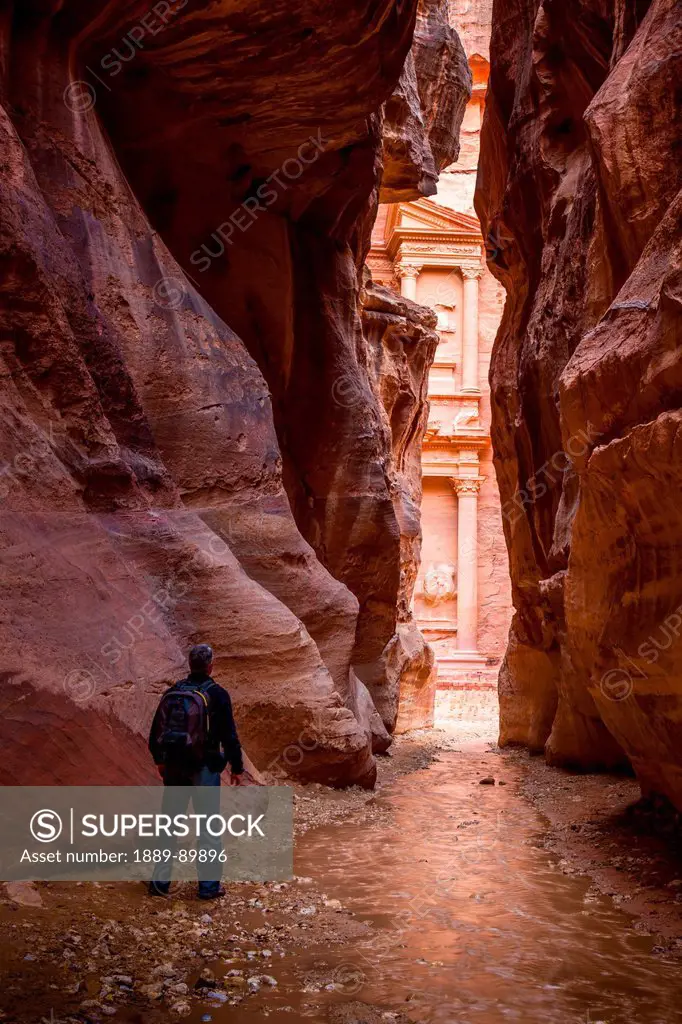 Man looking at Al Khazneh seen from natural narrow canyon; Petra, Jordan