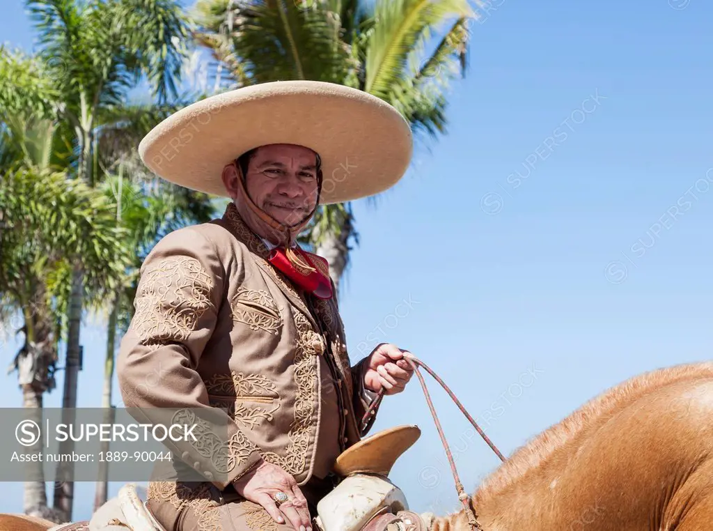 Man riding horse and dressed for Mexican rodeo and parade; Puerto Vallarta, Mexico