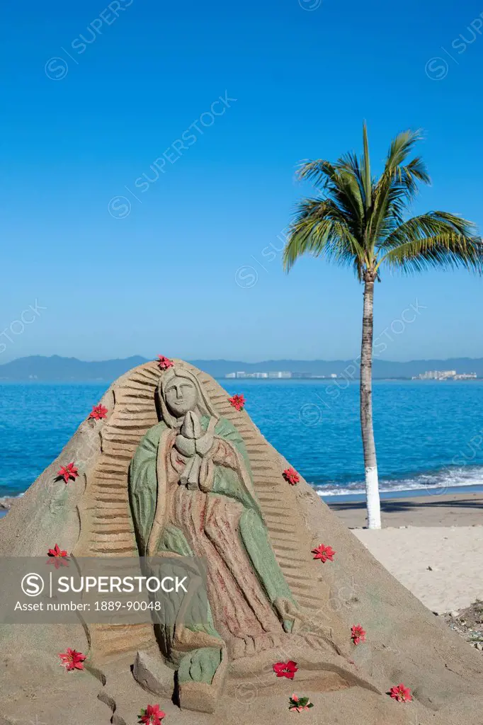 Sand sculpture with religious message located on beach; Banderas Bay, Puerto Vallarta, Mexico