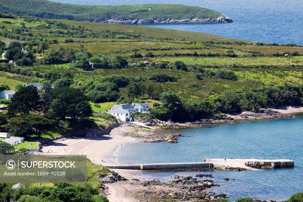 View of the coastline with a beach pier and houses;Kells county kerry ireland