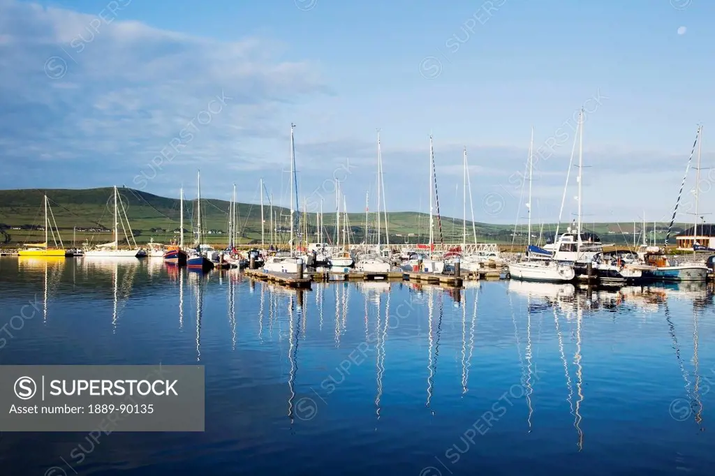 Boats and their reflection in the tranquil water of dingle harbour;Dingle county kerry ireland
