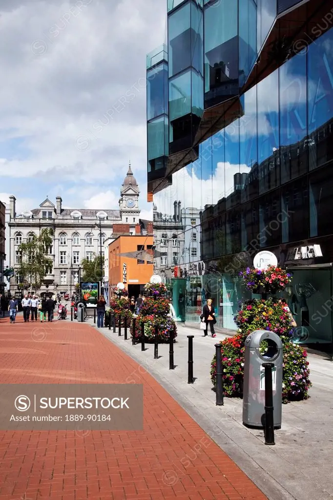 A pathway lined with flower planters and buildings in a busy urban centre;Dublin city county dublin ireland