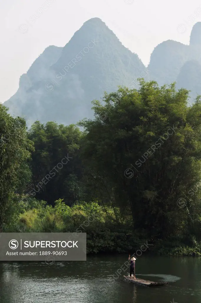 A man paddles in the Yulong River; Yangshuo, Guangxi, China
