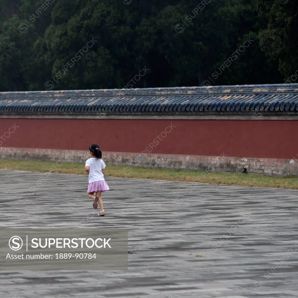 A young girl walks on a pathway at the Temple of Heaven; Beijing, China