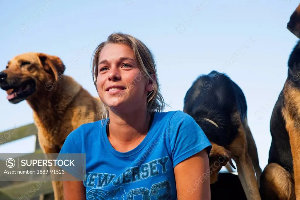 A Young Woman With Sheep Dogs At Blue Duck Lodge, In The Whanganui National Park; Whanganui, New Zealand