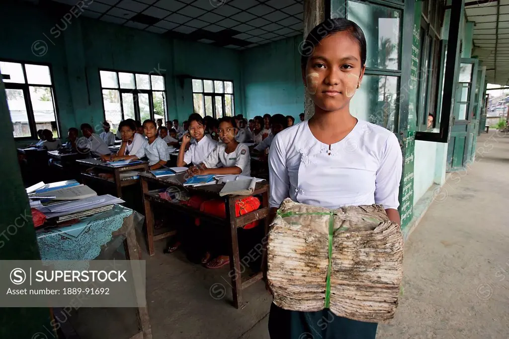 Secondary School Pupil With Damaged Text Books Following Cyclone Nargis; Labutta, Burma, Myanmar