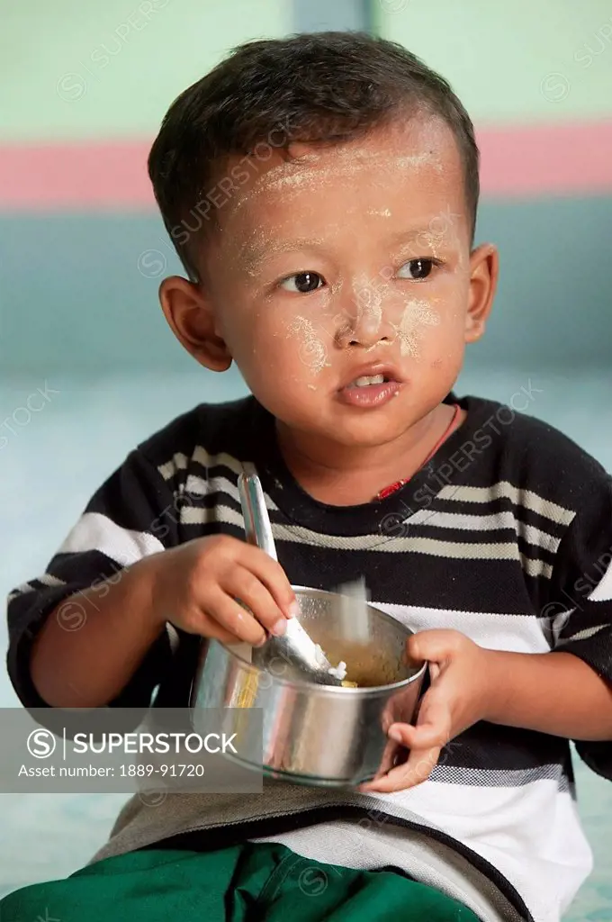 A Child Eating In Preschool Centre; Myanmar