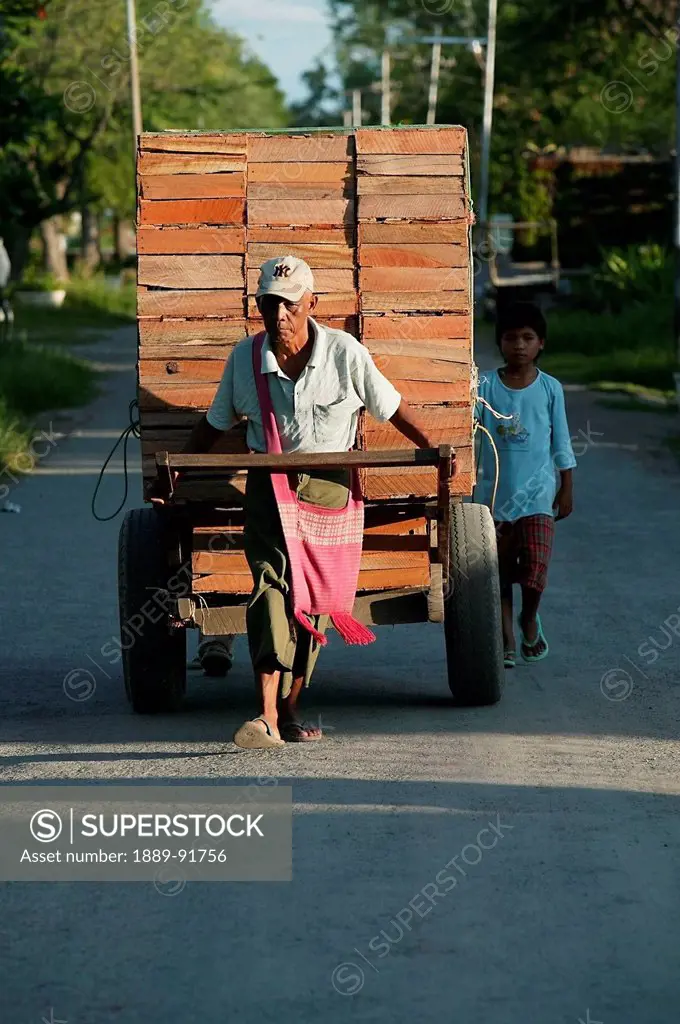 Labourer Pulling Hand Cart With Stack Of Boxes, In Tanggyi, Shan State, Myanmar; Ayeyarwady, Burma