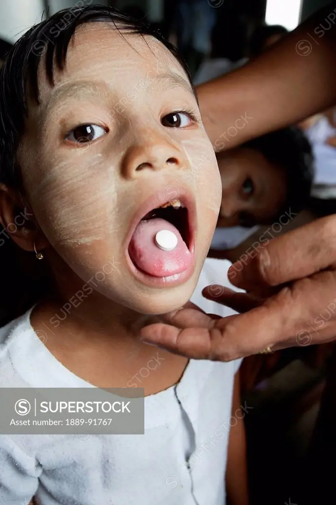 A Young Girl Receives Her Deworming Tablet From A Midwife As Part Of A Nationwide Program For School Children In The Primary School In Laputtaloke Tau...