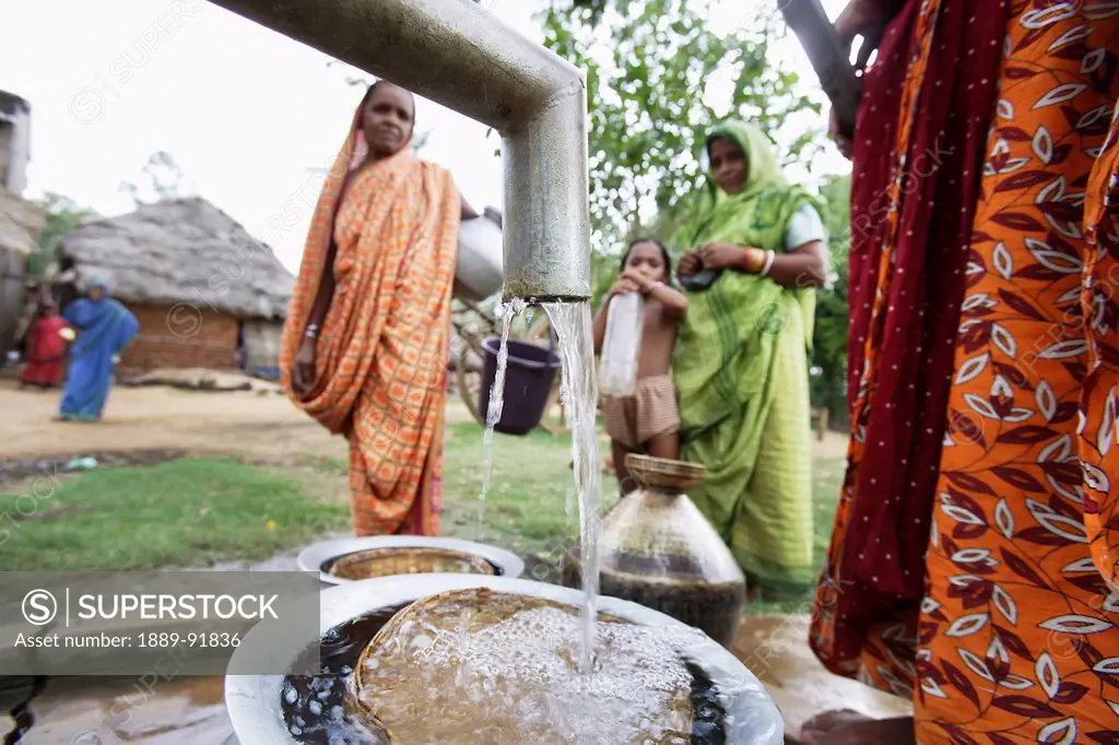 Women and girls collecting clean drinking water; Ratapata Village, Badamba, India