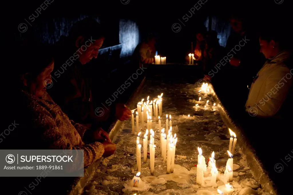 Aymara couple lighting candles at the Basilica de Virgen de la Candelaria, Copacabana, La Paz Department, Bolivia