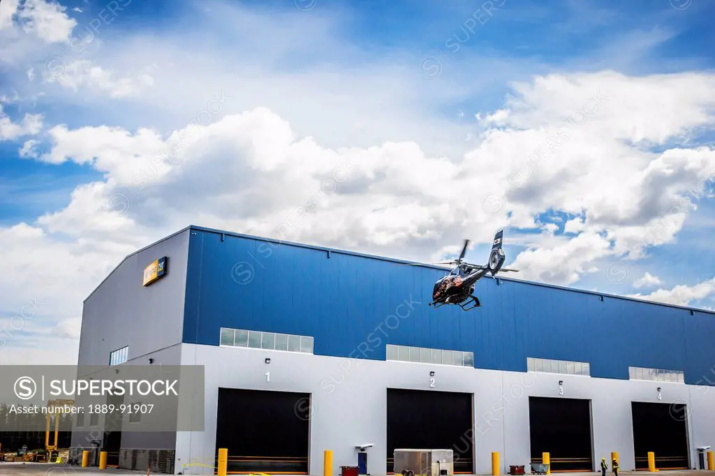 A helicopter lands in front of a building; Fort McMurray, Alberta, Canada