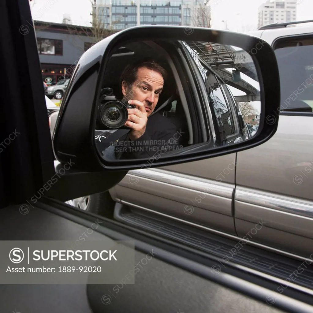 A Man With His Camera Reflected In A Car's Side View Mirror; Seattle, Washington, United States Of America