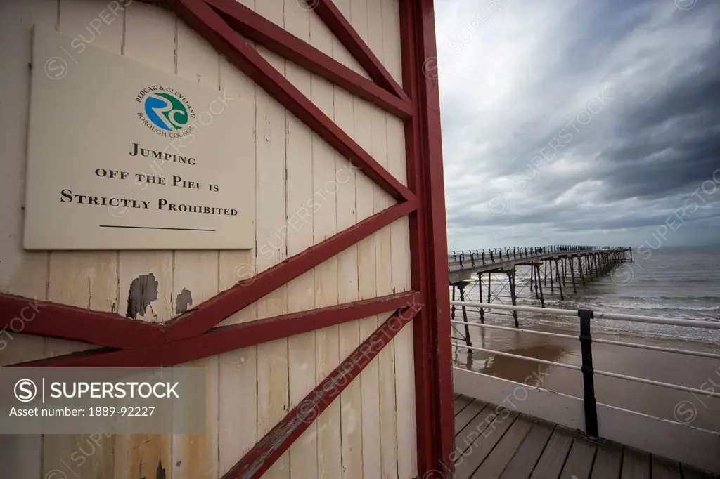 Sign on the side of a building to prohibit jumping off the pier; Saltburn, North Yorkshire, England