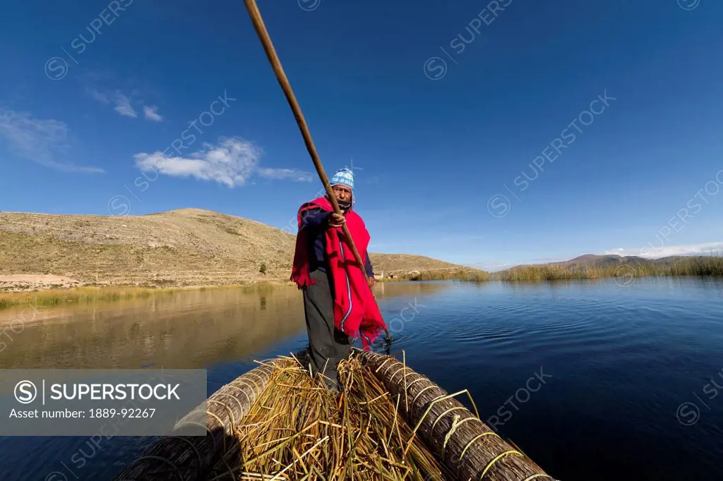 Aymara man rowing a totora reed boat on Lake Titicaca, La Paz Department, Bolivia
