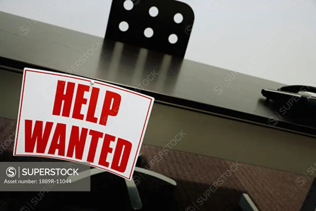 Help wanted sign on a desk