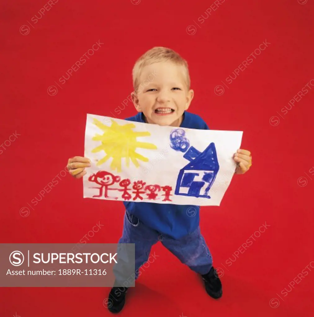 Boy posing for the camera shot while holding a painting