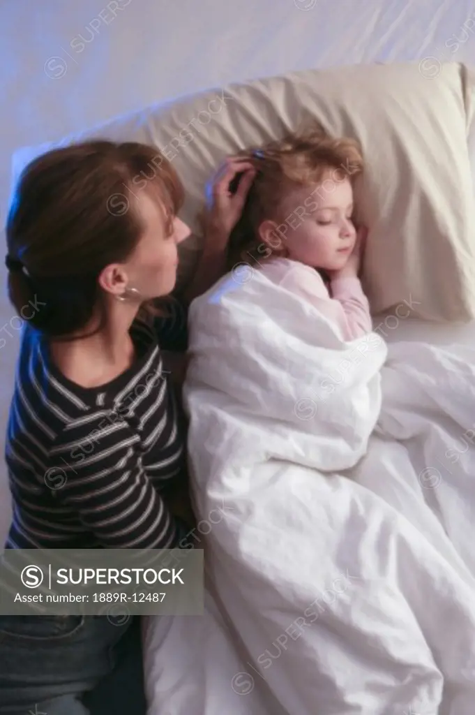 Mother watching daughter sleep