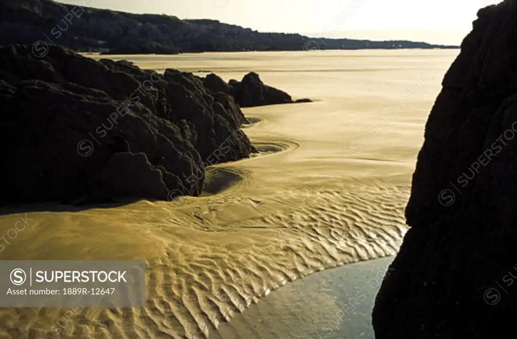 Waves rippling on a sandy shore in Devon, England