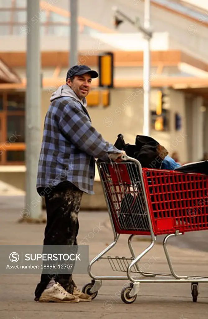 Homeless man pushing a shopping cart