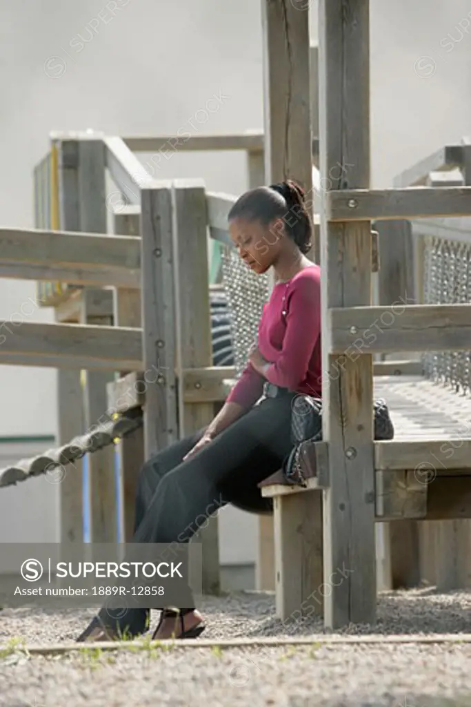 Woman sitting alone on a playground