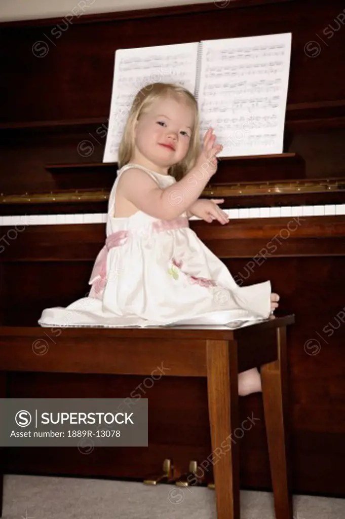 Girl sitting on piano bench