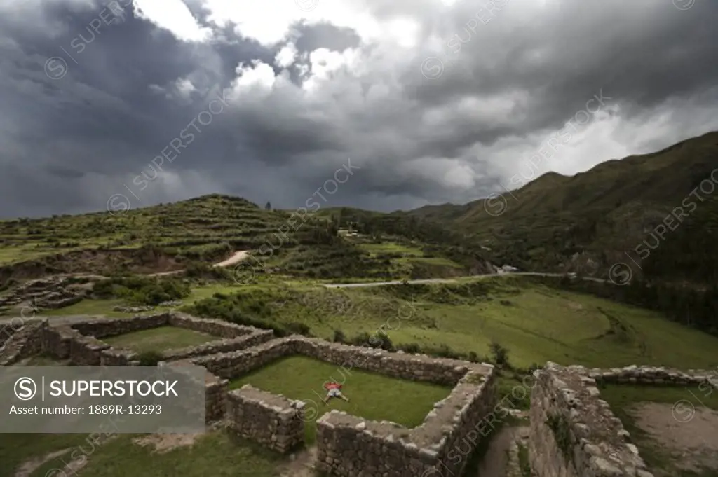A person meditates in ancient Incan ruins outside Cuzco, Peru