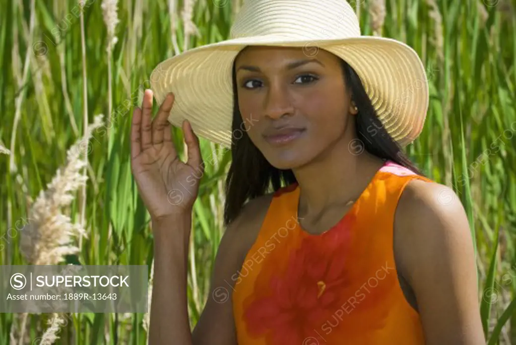 Woman in hat in tall grass  