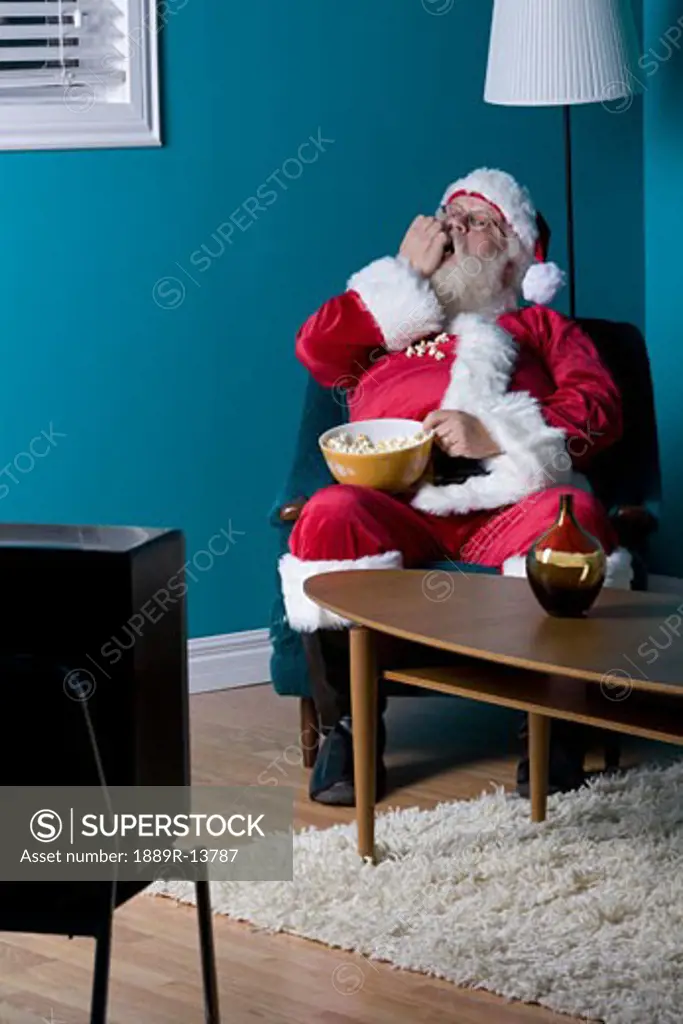 Santa sitting and eating popcorn