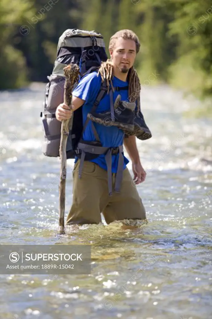 Kananaskis, Alberta, Canada; Man crossing a river