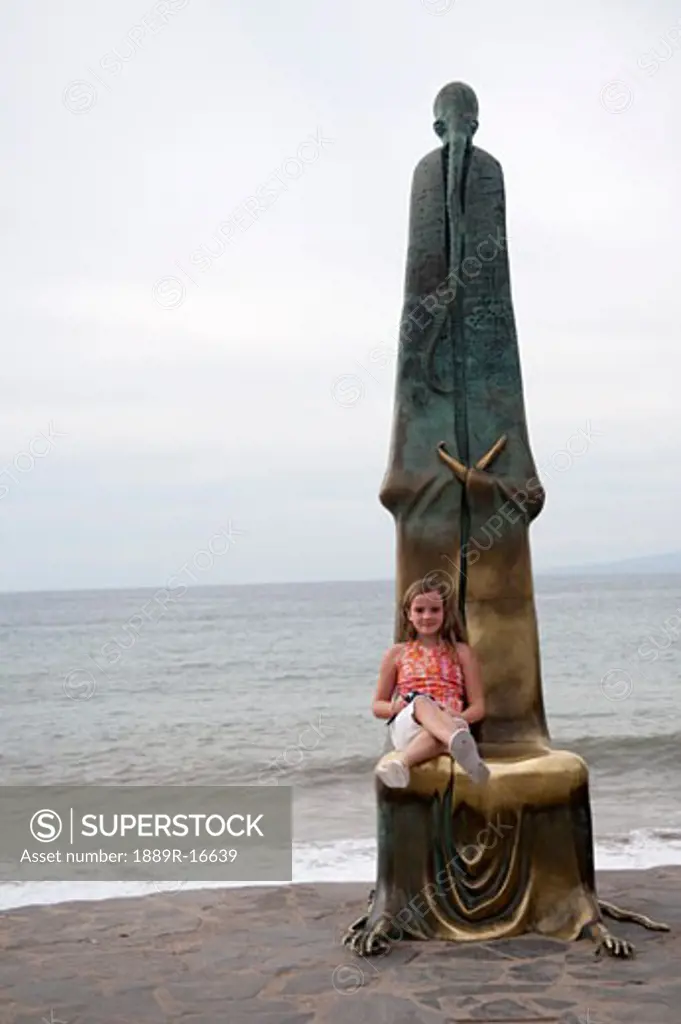 Puerto Vallarta, Mexico; Girl sitting by a statue  