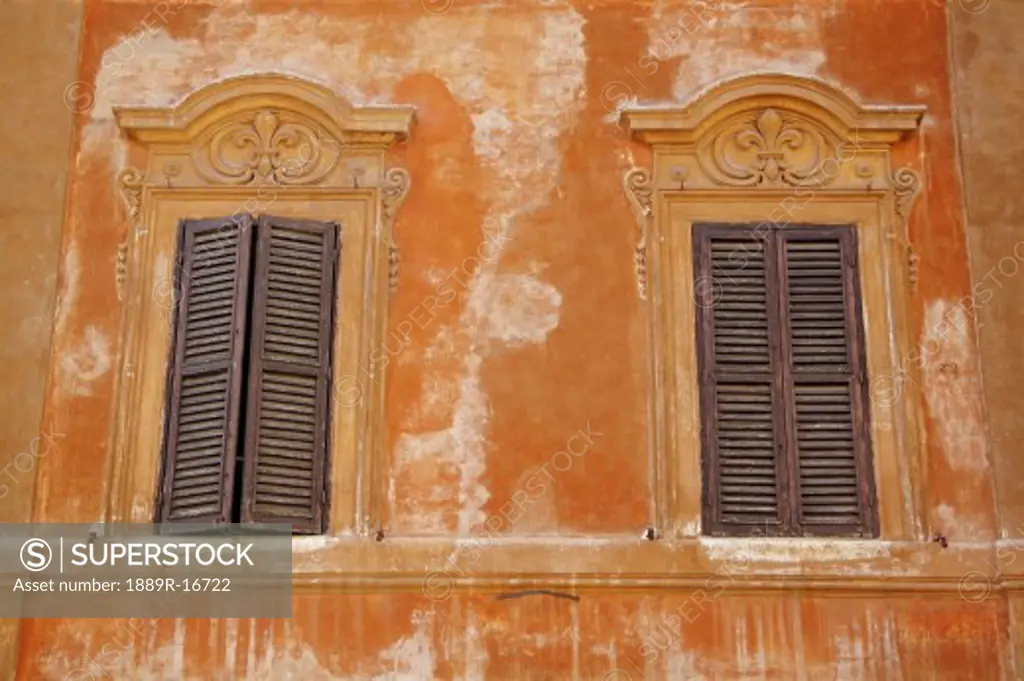 Rome, Italy; Two windows with shutters
