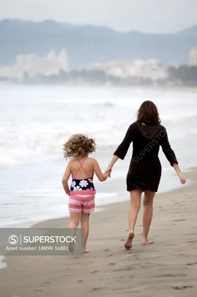 Puerto Vallarta, Mexico; Mother and daughter walking on the beach