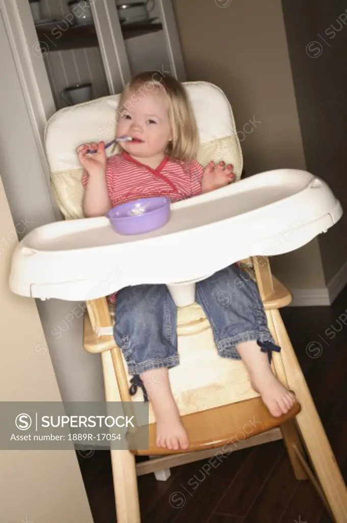 Young girl in a high chair
