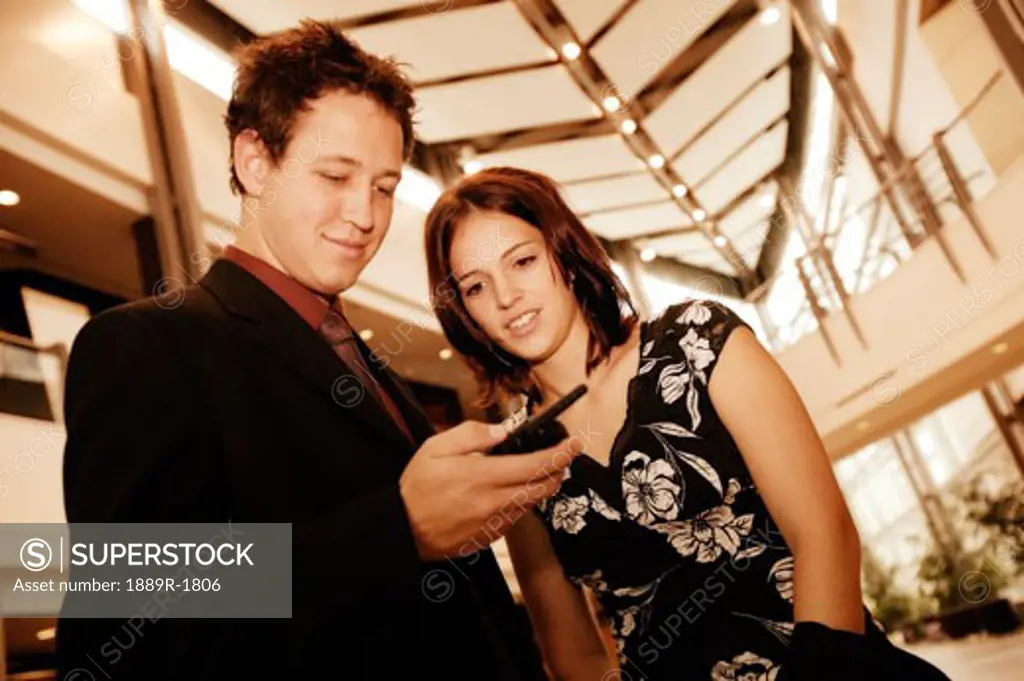 Professional couple looking at cell phone