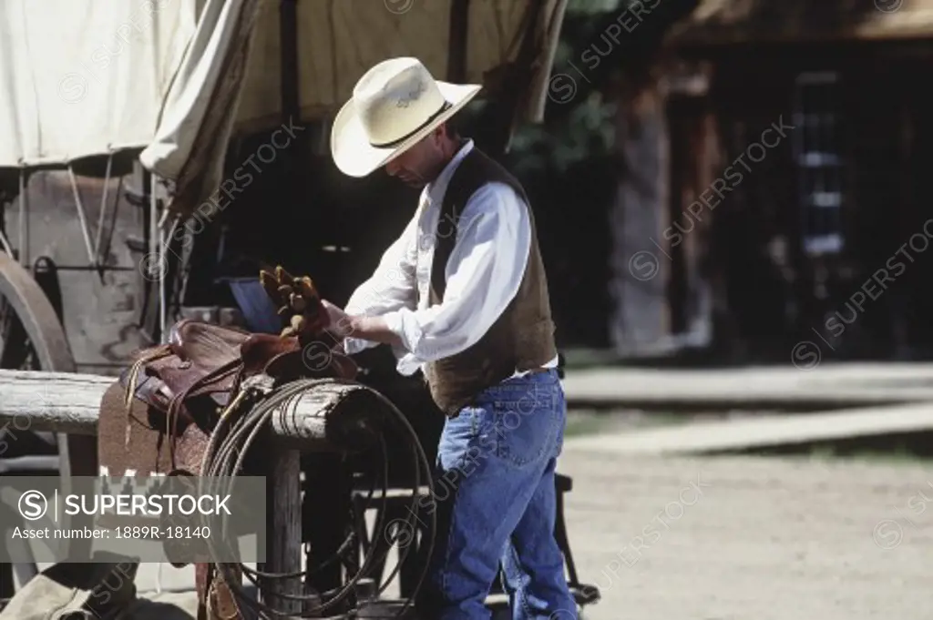 Cowboy working on saddle