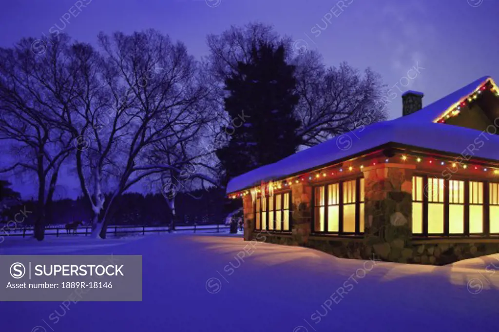 Cottage with Christmas lights in the snow