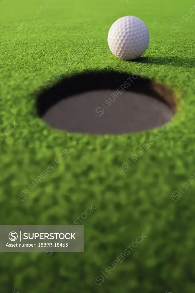 Golf ball on lip of cup