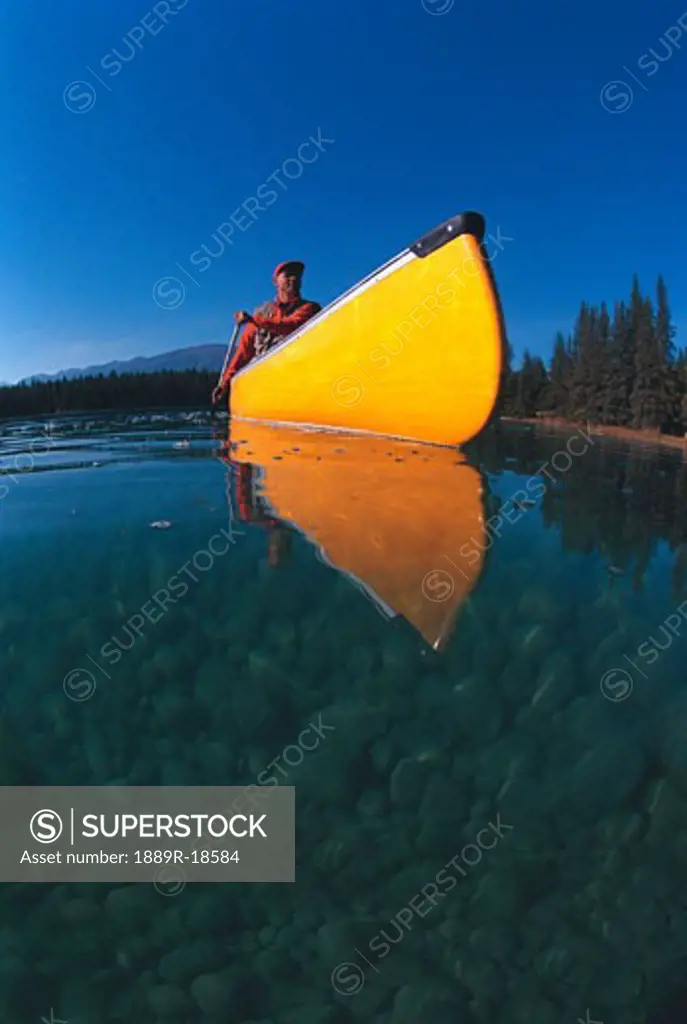 Man in yellow canoe on lake