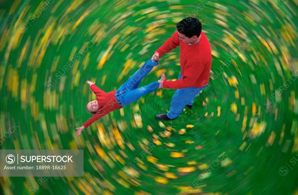 Man swinging child through air