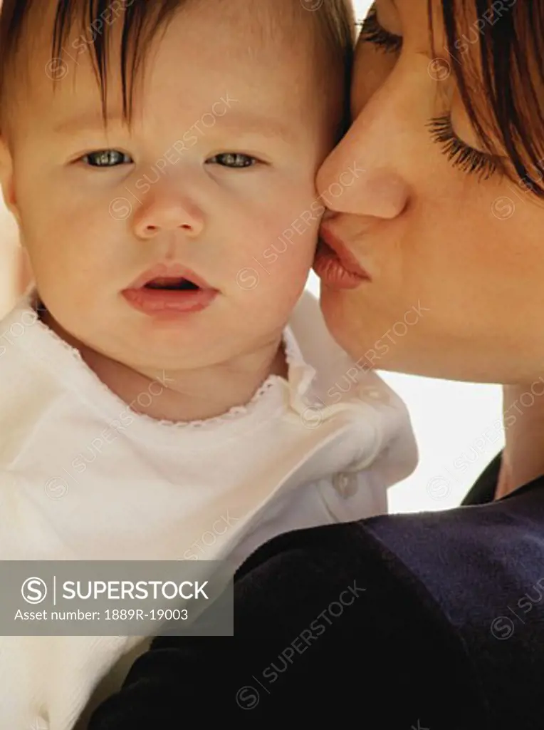 Mother kissing baby