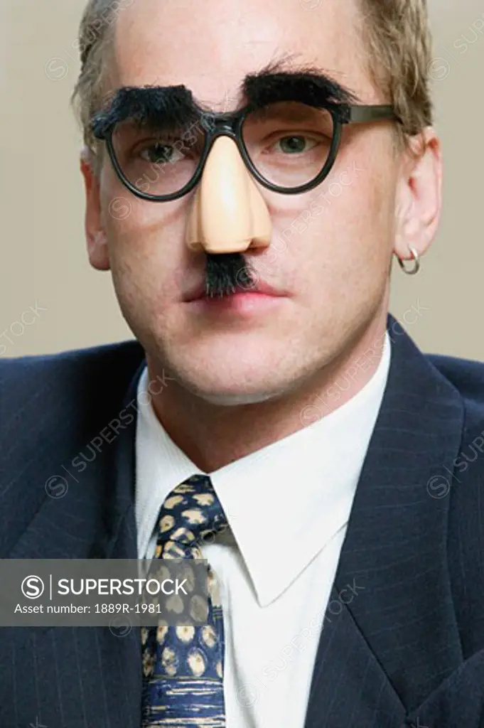 Thoughtful businessman wearing Groucho Marx mask