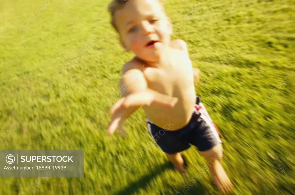 Boy runs through grass