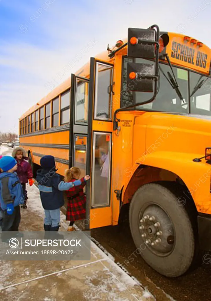 Elementary schoolchildren boarding school bus on a winter day in Edmonton Alberta Canada