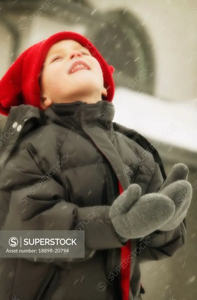 Child enjoys catching snowflakes